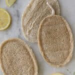 Loofas with lemons on a white marble table