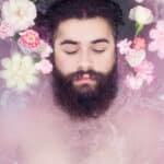 Bearded man deeply relaxing in a flower bath