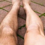 A man's waxed leg next to an unwaxed leg